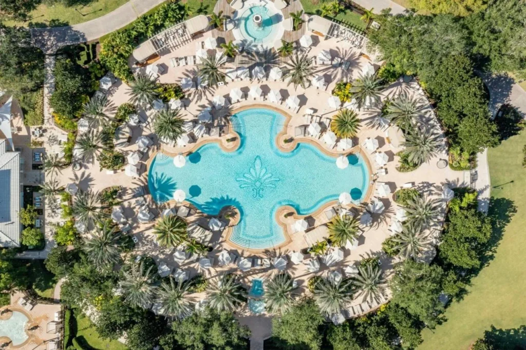 Vista aérea de la piscina con palmeras y sombrillas blancas en el Ritz-Carlton Orlando Grande Lakes