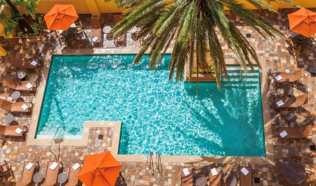 Overhead view of the pool, loungers and orange umbrellas at Embassy Suites Orlando Convention Center