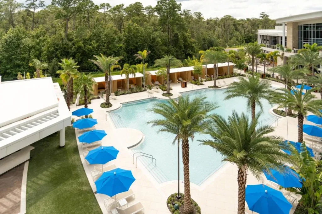Vista aérea de la piscina con sombrillas azules y palmeras en el JW Marriott Orlando Bonnet Creek