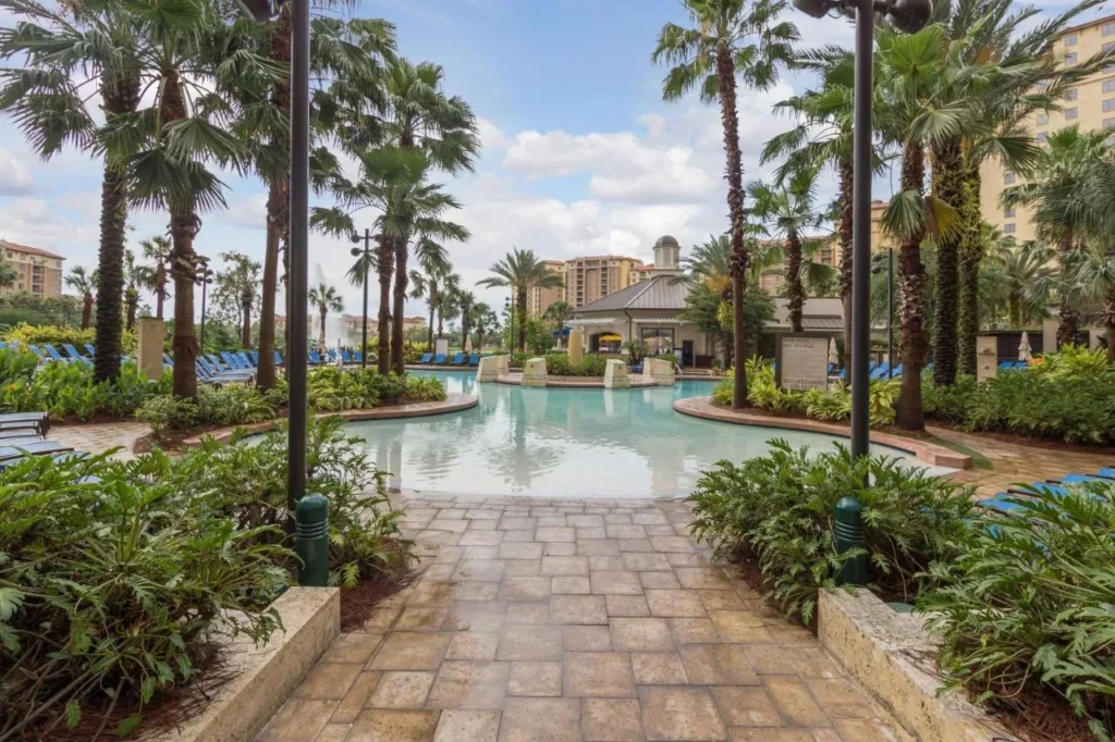 Piscina y tumbonas bordeadas de palmeras en Wyndham Grand Orlando Resort Bonnet Creek