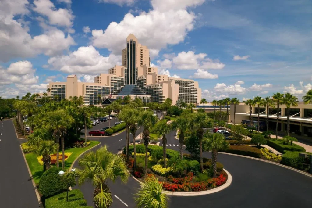 Entrada y estacionamiento bordeados de palmeras frente a la torre Marriott del Orlando World Center