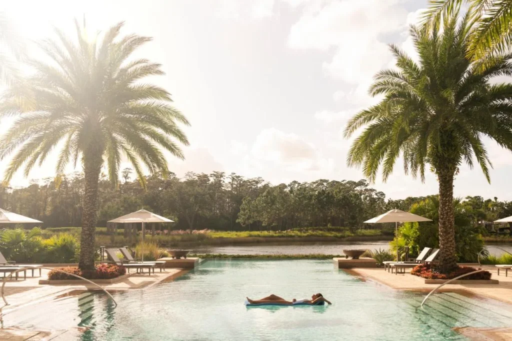 Palm-lined infinity-edge pool facing the lake at Four Seasons Resort Orlando