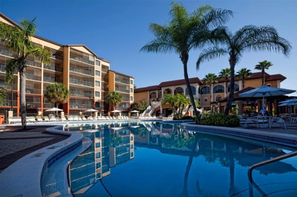 Palm-lined outdoor pool reflecting the villa buildings at Westgate Lakes Resort and Spa