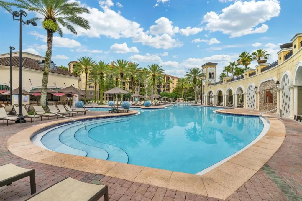 Palm-lined resort pool with Tuscan-style arches at Hilton Grand Vacations Club Tuscany Village Orlando