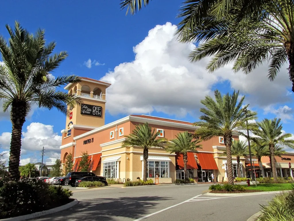 Palm trees, corner tower and storefronts at Orlando Vineland Premium Outlets on a sunny day