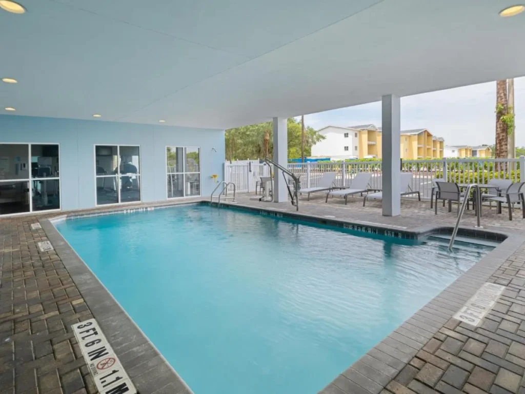 Piscina climatizada parcialmente cubierta con tumbonas en Holiday Inn Express and Suites Lakeland North I-4