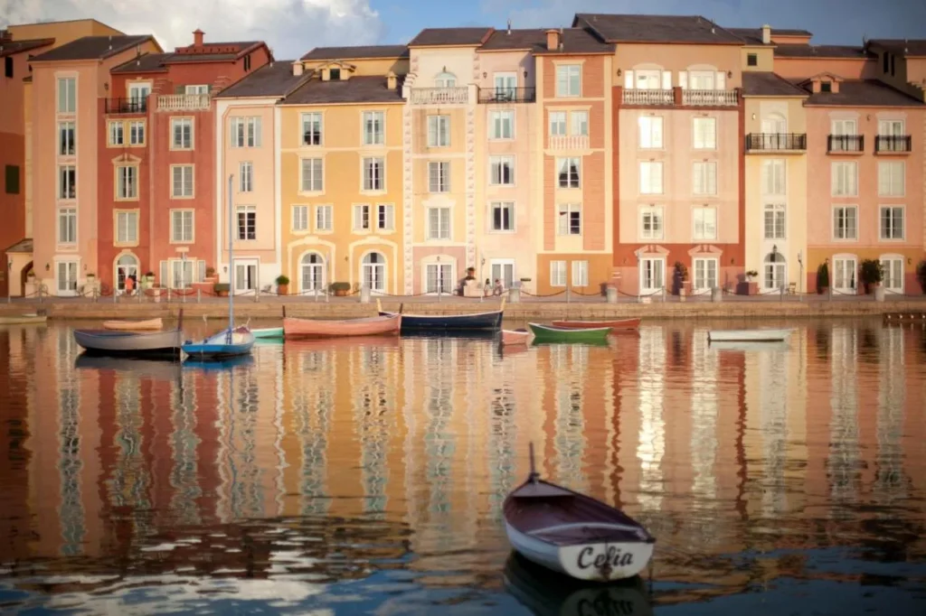 Fachadas frente al puerto en colores pastel y pequeñas embarcaciones reflejadas en la bahía en Loews Portofino Bay Hotel