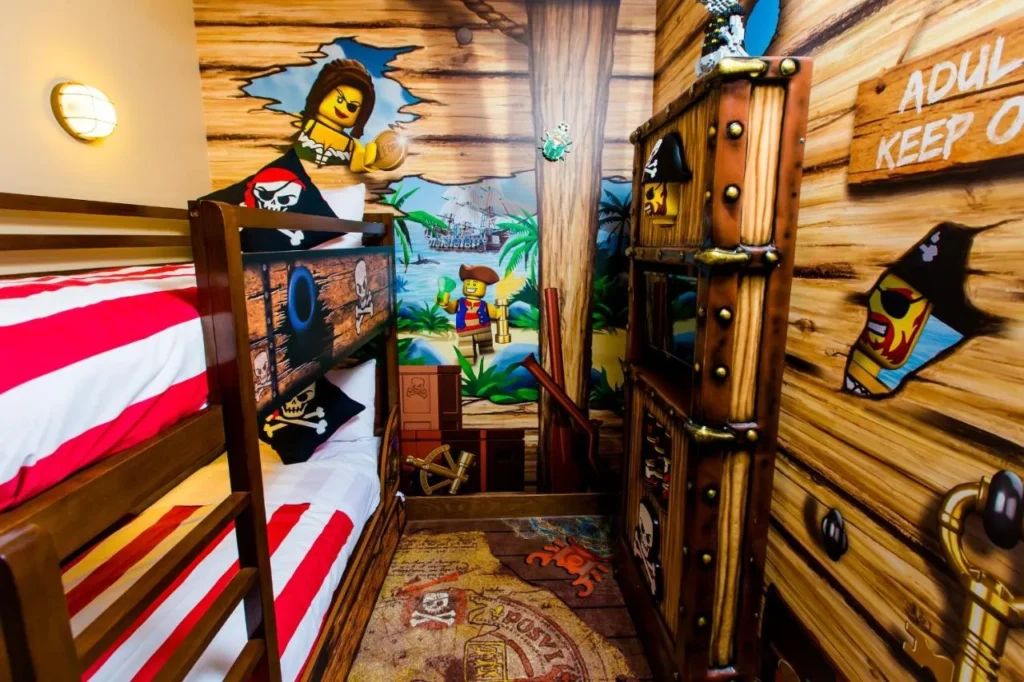 Pirate-themed kids' sleeping area with bunk bed and wooden ship decor at the LEGOLAND Hotel