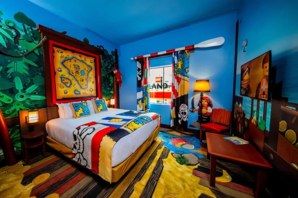 Pirate-themed LEGO room at LEGOLAND Florida with king bed below a Pirate Island Hotel treasure map