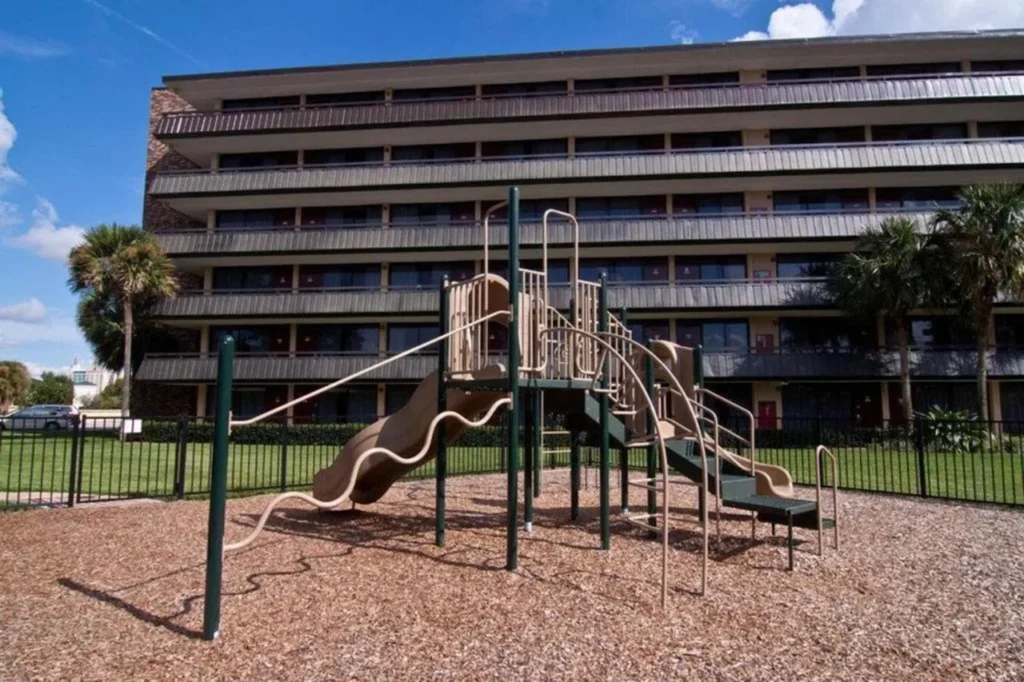 Playground with slides in front of a guest wing at Rosen Inn International