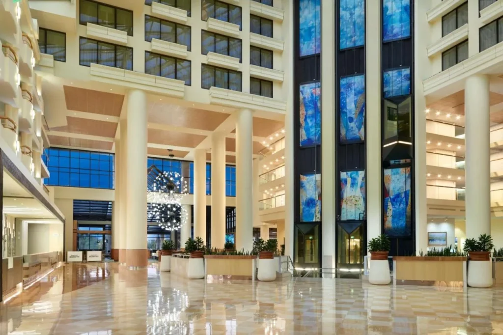Polished-floor lobby atrium with tall columns and blue art panels at Orlando World Center Marriott