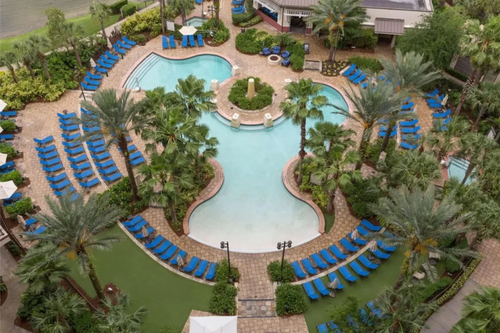 Piscina rodeada de tumbonas azules y palmeras vistas desde arriba en Wyndham Grand Orlando Bonnet Creek