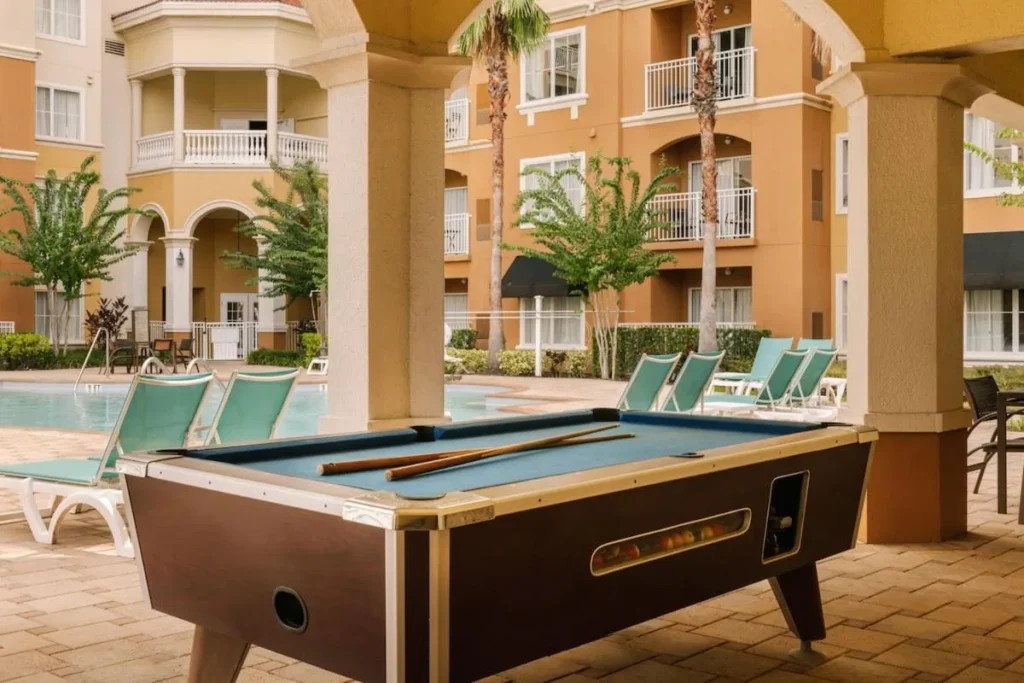 Mesa de billar bajo una galer&iacute;a cubierta junto a la piscina en The Point Hotel & Suites