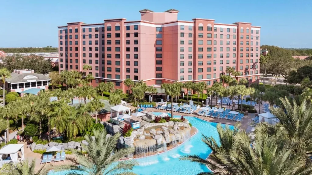 Pool with a rock waterfall below the pink tower of Caribe Royale Orlando