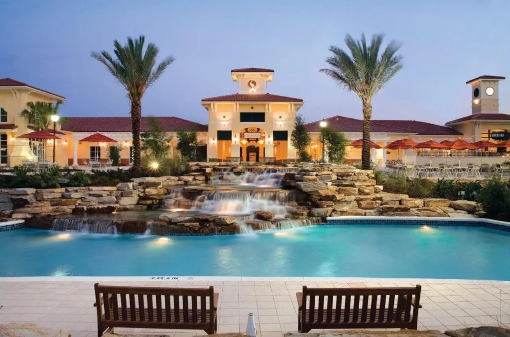 Pool with a rock waterfall in front of an Exchange building at Holiday Inn Club Vacations at Orange Lake Resort