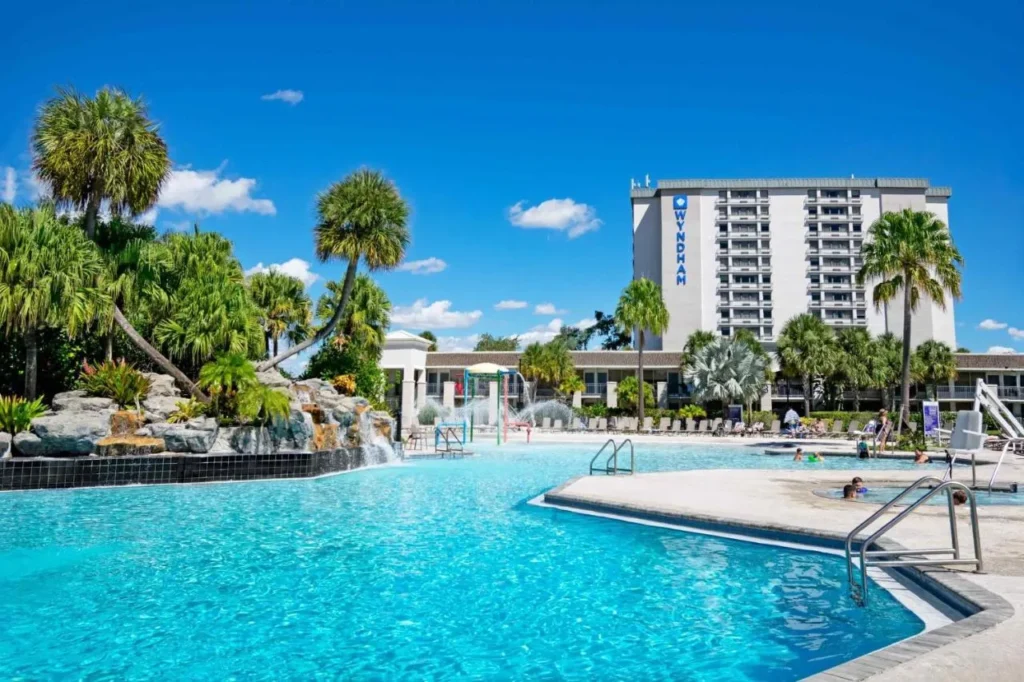 Pool with a rock waterfall, kids' splash area and the Wyndham tower at Wyndham I-Drive Avanti