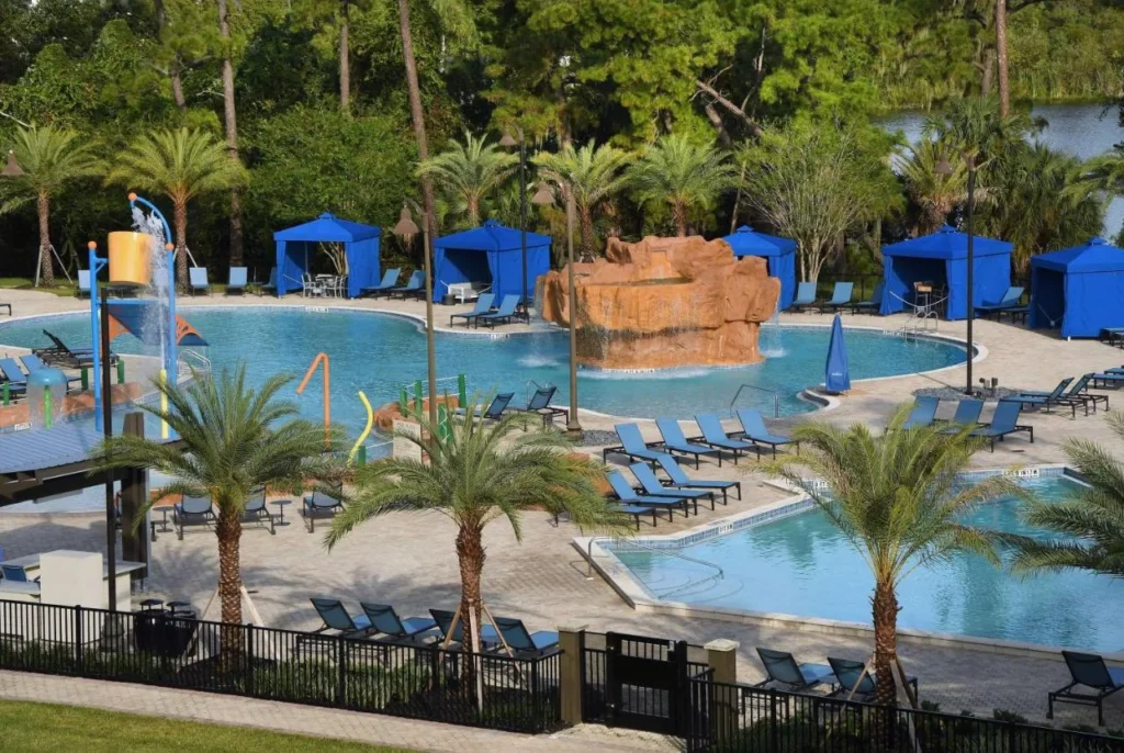 Piscina con cascada de roca, &aacute;rea de chapoteo y caba&ntilde;as azules en Wyndham Garden Lake Buena Vista