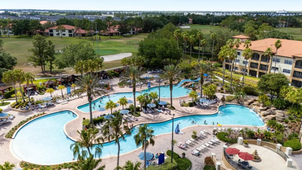 Pool with a waterslide and cabanas near villa buildings and golf, Orange Lake Resort