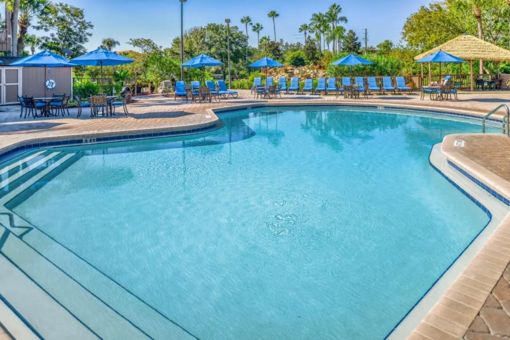 Piscina con sombrillas azules y una cabaña tiki en Hilton Vacation Club Polynesian Isles Kissimmee
