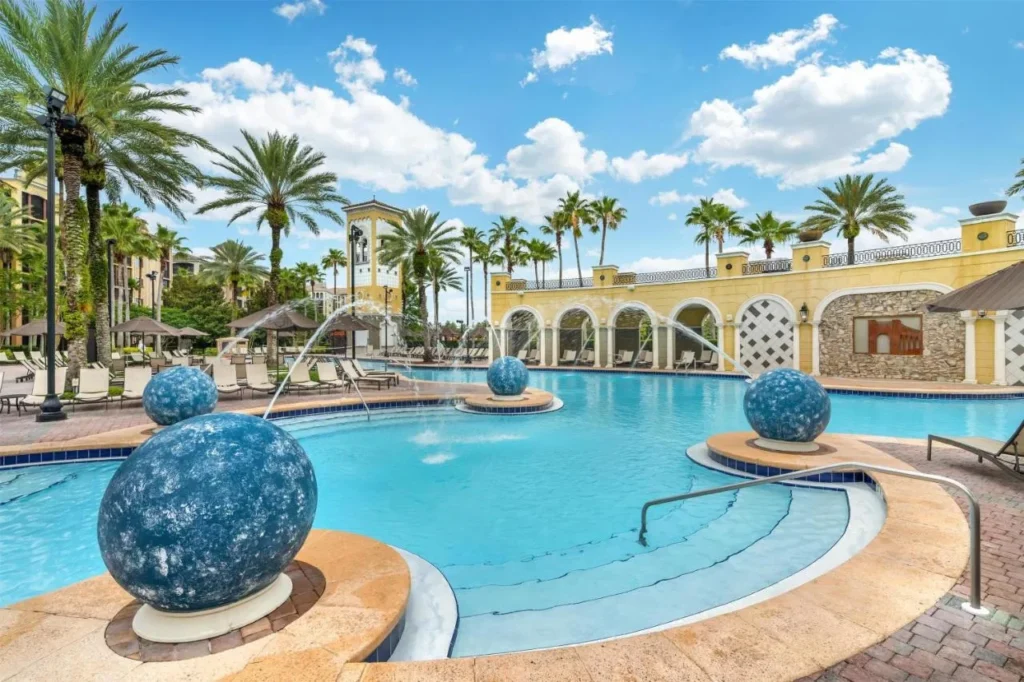 Piscina con fuentes, esferas azules y arcadas en Hilton Grand Vacations Club Tuscany Village