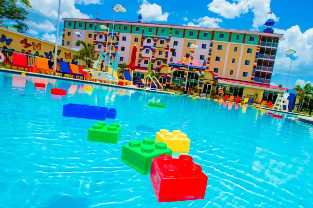 Pool with giant floating LEGO bricks in front of the colorful LEGOLAND Hotel