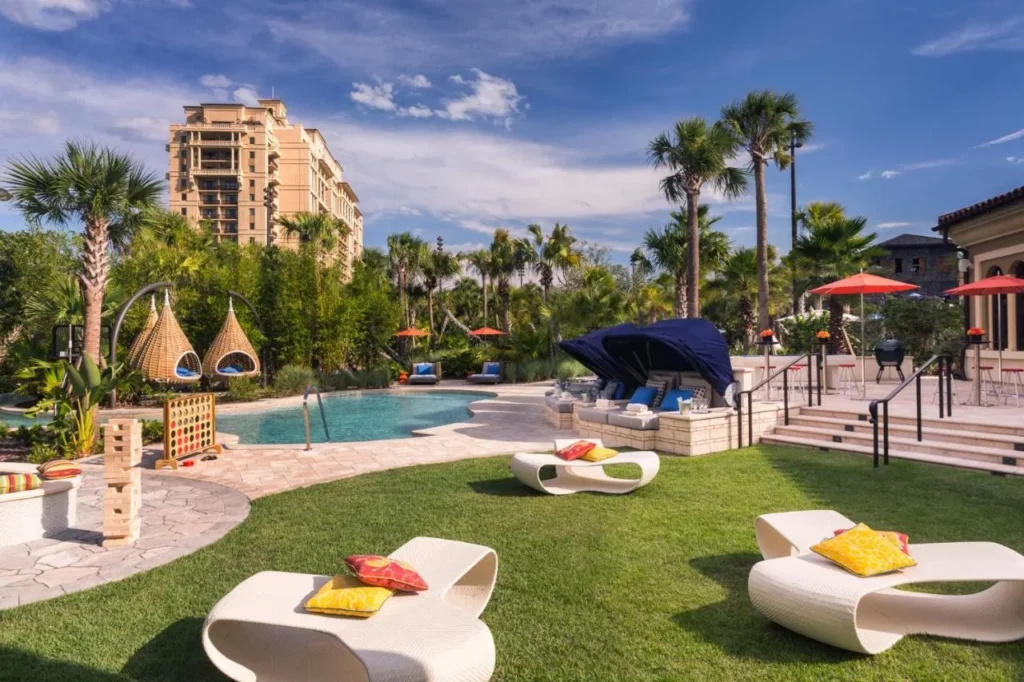 Piscina con juegos de c&eacute;sped, sillas nido colgantes y una caba&ntilde;a debajo de la torre en Four Seasons Resort Orlando
