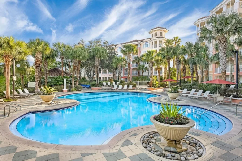 Piscina con tumbonas, palmeras y edificios de villas en Marriott's Grande Vista en Orlando