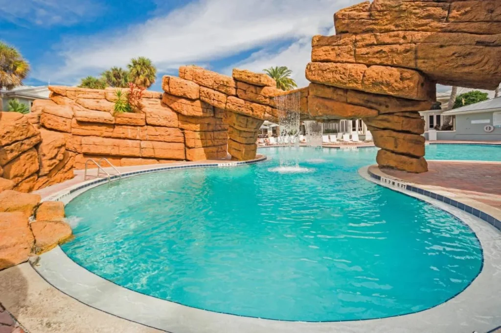 Pool with rock waterfall and lounge chairs at Radisson Resort at the Port in Cape Canaveral