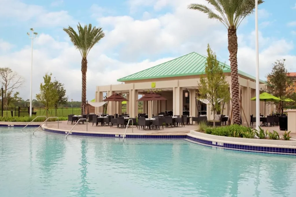 Piscina con escalones y un pabell&oacute;n de comedor junto a la piscina a la sombra en Signia by Hilton Orlando Bonnet Creek