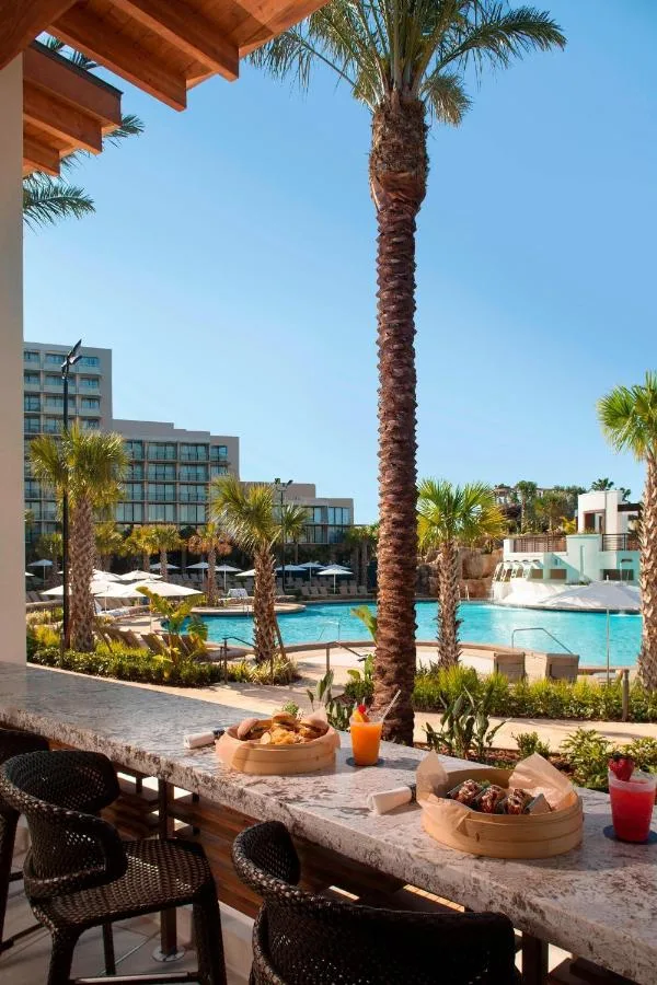 Bar junto a la piscina con comida y bebidas frente a la piscina de la laguna en Orlando World Center Marriott