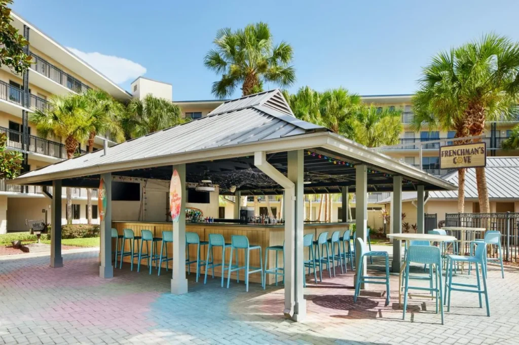Poolside bar pavilion with turquoise stools and palms at Staybridge Suites Orlando Royale Parc Suites