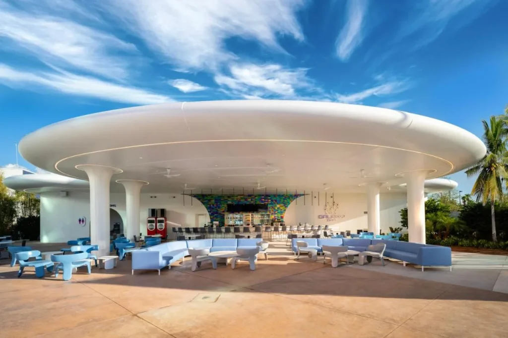 Poolside bar under a white curved canopy with blue lounge seating at Universal Stella Nova Resort