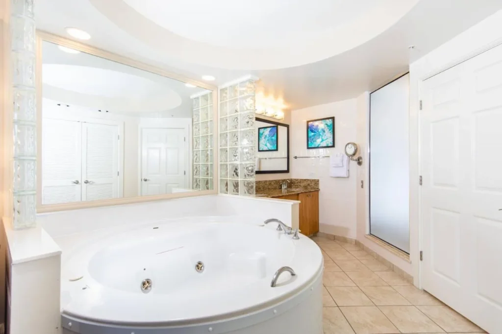 Ba&ntilde;o principal con ba&ntilde;era de hidromasaje redonda y paredes de bloque de vidrio en Marriott's Cypress Harbour