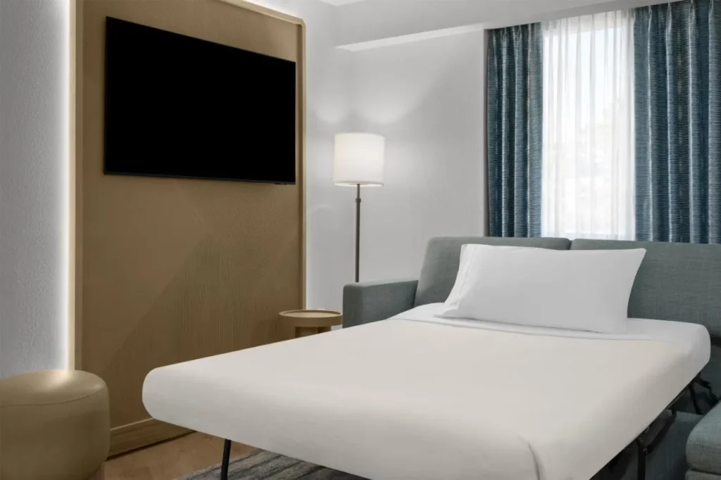 Sof&aacute; cama extra&iacute;ble en una sala de estar suite en Embassy Suites Orlando ICON Park