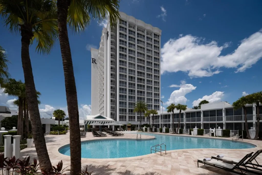 Renaissance Orlando Resort and Spa torre y piscina curvada enmarcada por palmeras