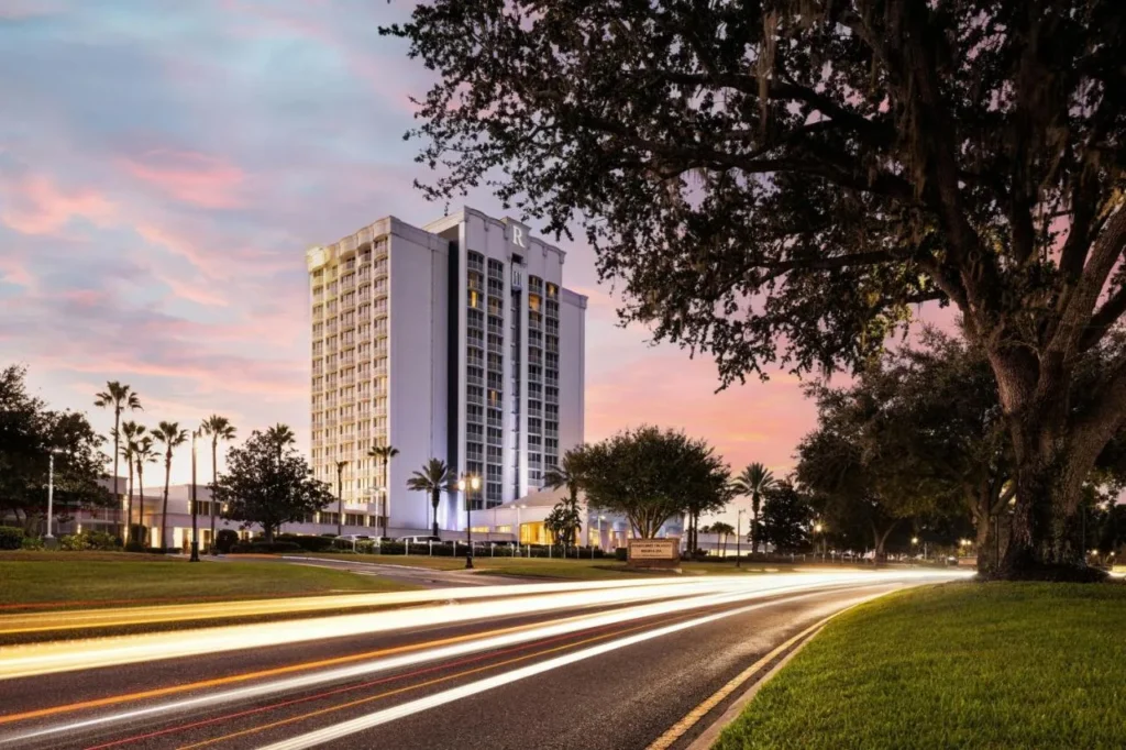 Torre Renaissance Orlando Resort and Spa al atardecer con senderos de luz de automóviles en el frente