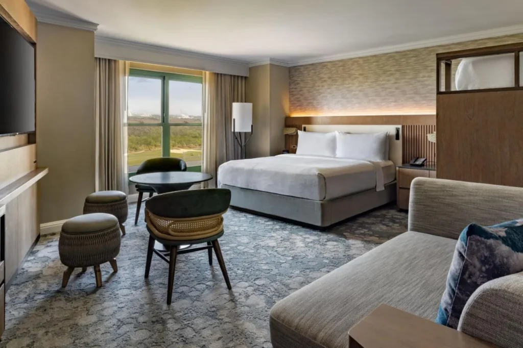 Habitación King renovada con sofá, mesa pequeña y vistas al campo de golf en el JW Marriott Orlando Grande Lakes