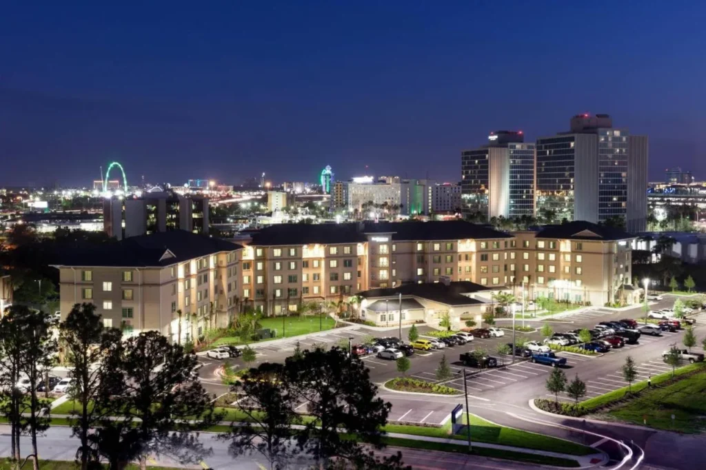 Residence Inn Near Universal Orlando y su estacionamiento por la noche, con el horizonte I-Drive detr&aacute;s