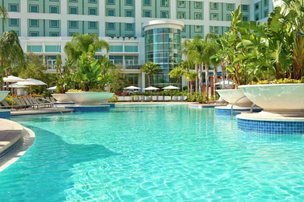Resort pool with palm planters below the guest tower at Hilton Orlando