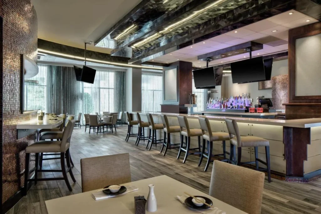 Restaurant at Signia by Hilton Bonnet Creek with chopsticks on tables and a backlit bar