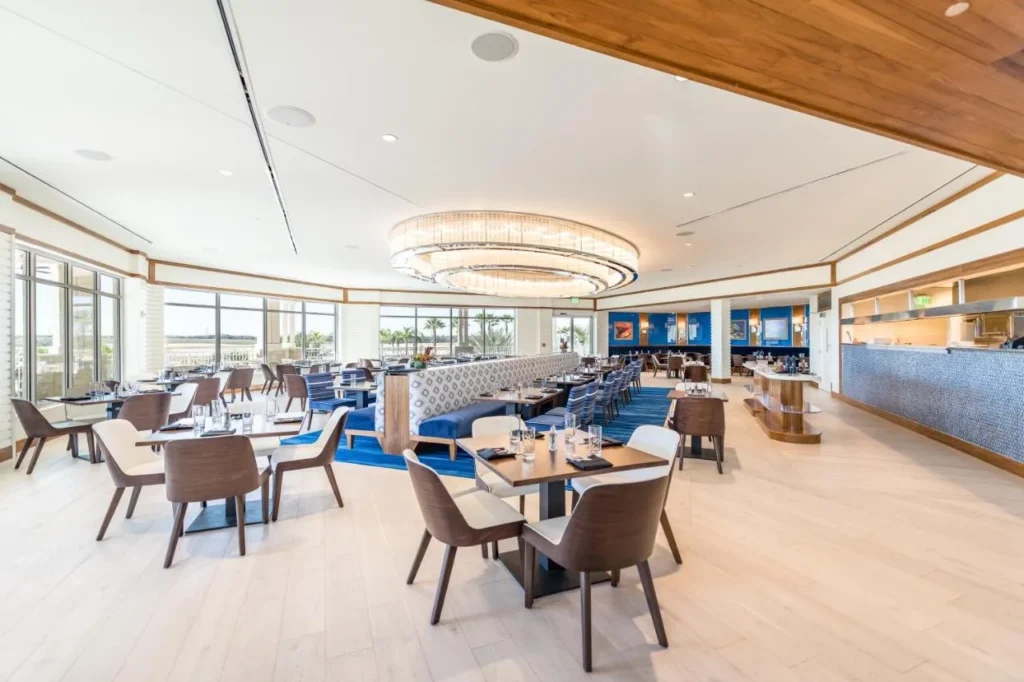 Restaurant dining room at Margaritaville Resort Orlando with a ring chandelier, booths and tiled counter