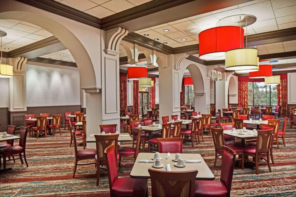 Comedor del restaurante para el desayuno con sillas rojas en Wyndham Garden Lake Buena Vista