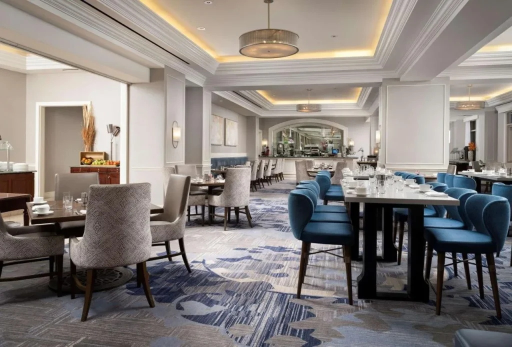 Restaurante comedor con sillas azules y una estación de buffet en el Waldorf Astoria Orlando