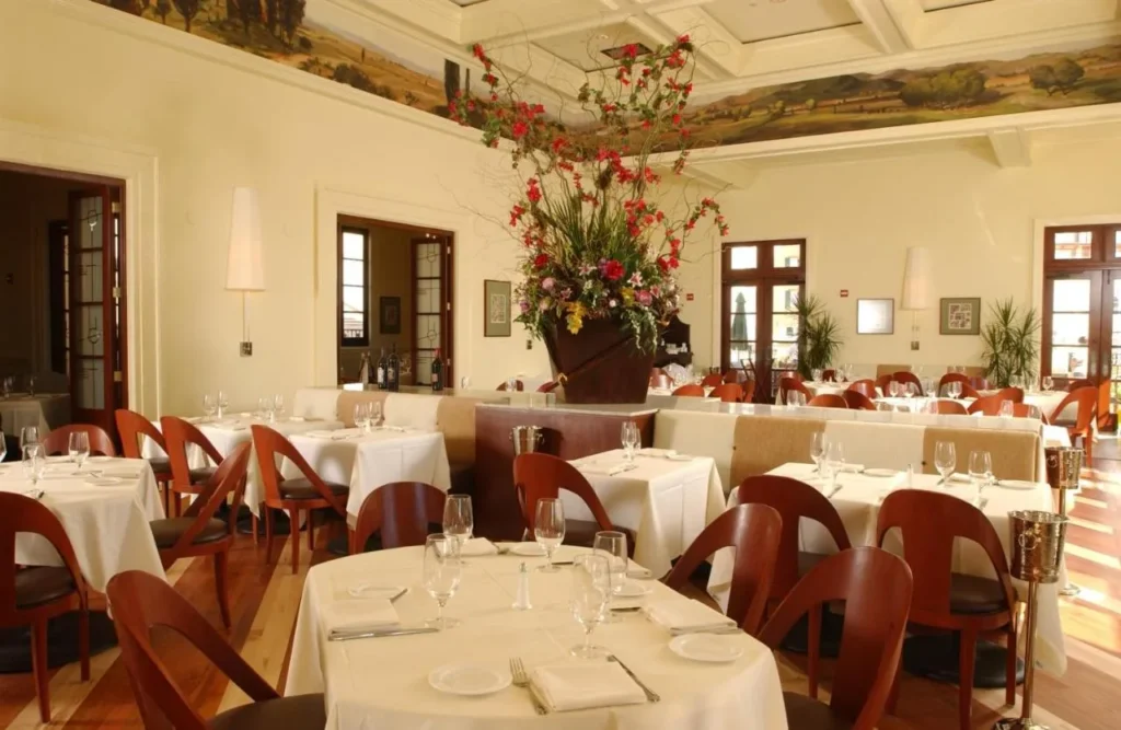 Restaurante comedor con manteles blancos y flores en Loews Portofino Bay Hotel
