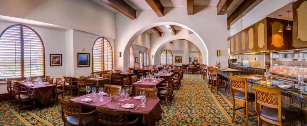Restaurant with arched windows, burgundy tablecloths and an open kitchen counter at Rosen Shingle Creek