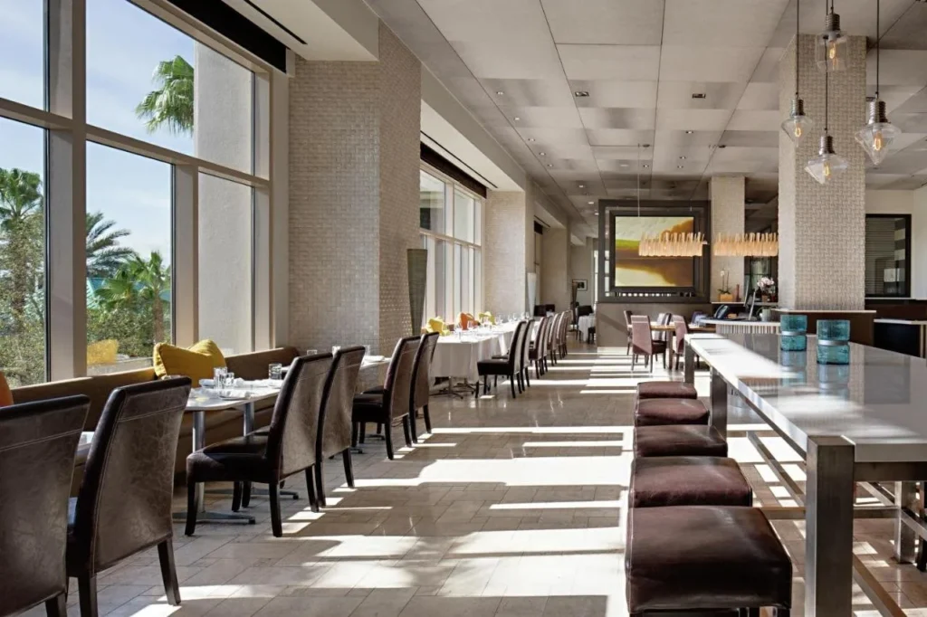 Restaurante con ventanales y una mesa común en Signia by Hilton Orlando Bonnet Creek