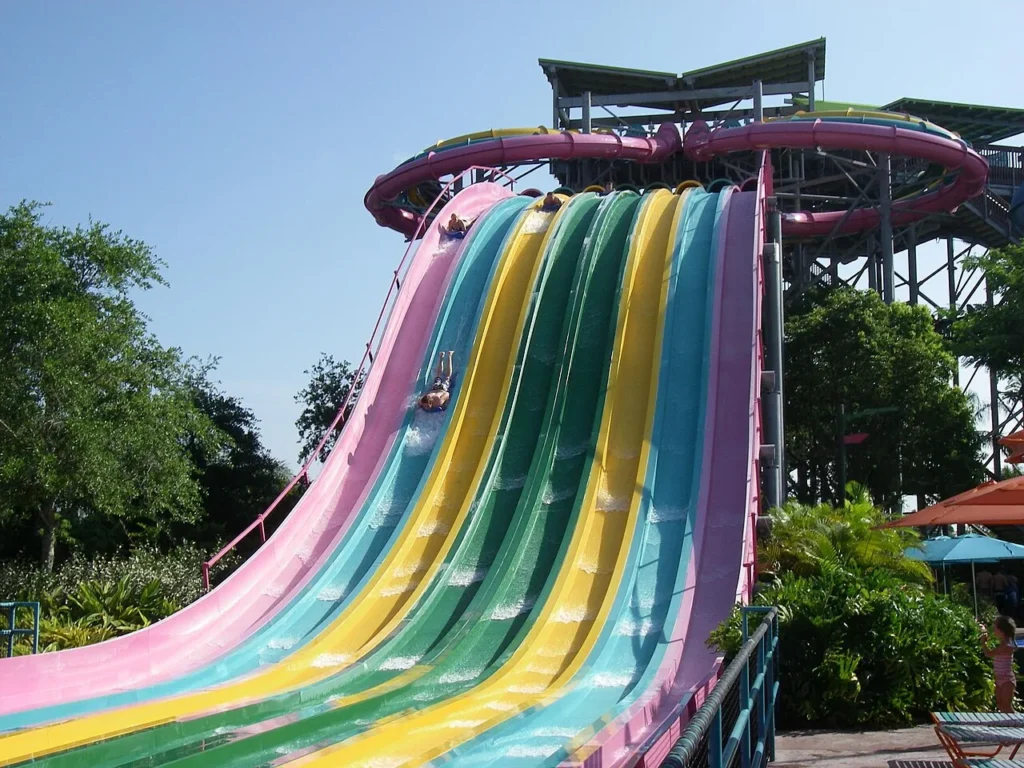 Riders racing head-first down the colorful multi-lane Taumata Racer mat slide at Aquatica Orlando
