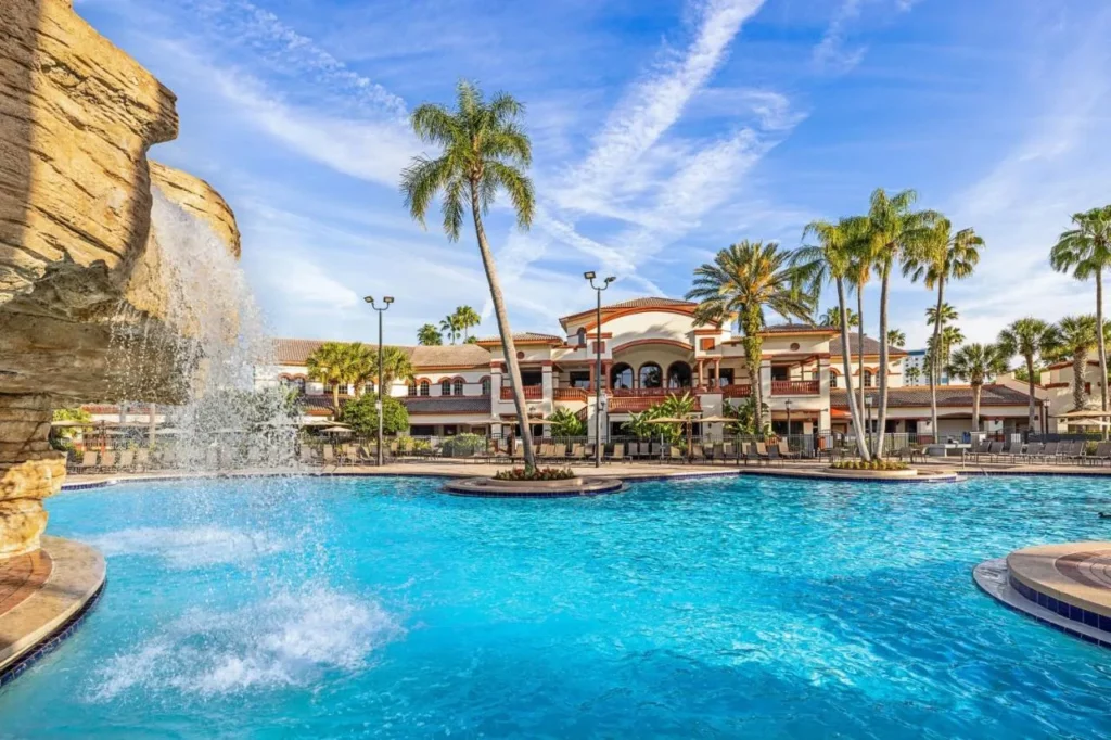 Rock waterfall pouring into a palm-lined pool at Sheraton Vistana Villages Resort Villas