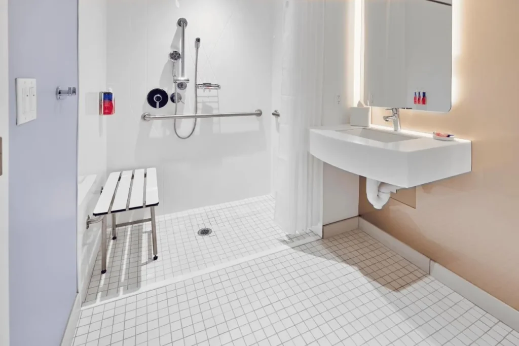 Roll-in shower with a bench and grab bars in an accessible room, Universal Stella Nova Resort