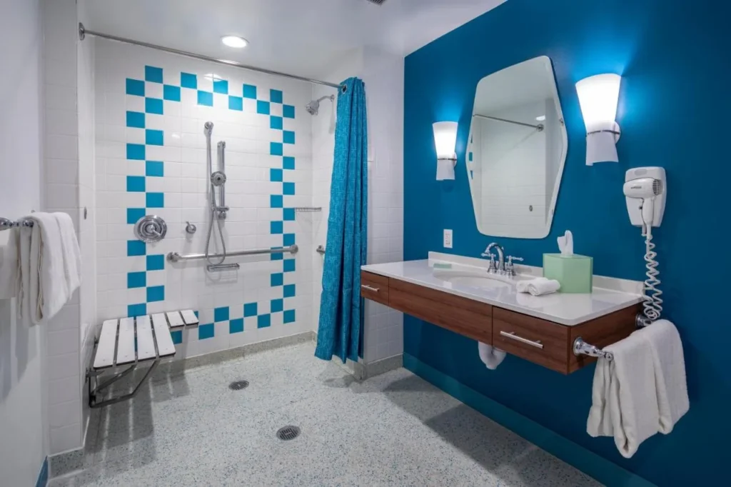 Roll-in shower with fold-down bench, grab bars and hand-held shower at Universal's Cabana Bay Beach Resort